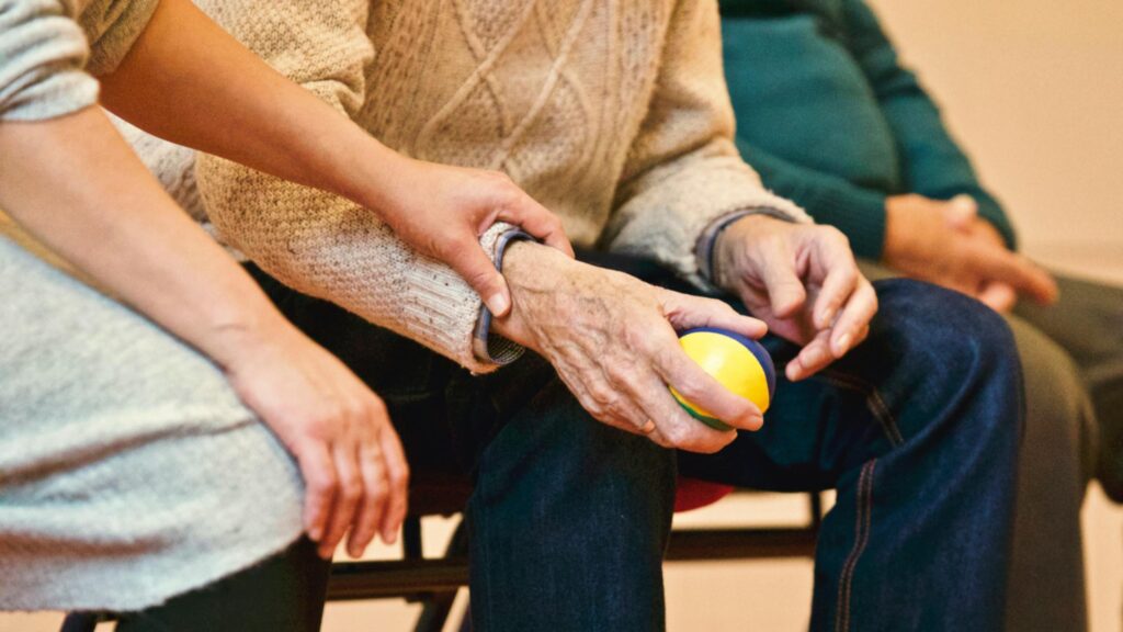 Patient story showing a grateful woman holding hands with a nurse in a hospital room, symbolizing compassion and connection
